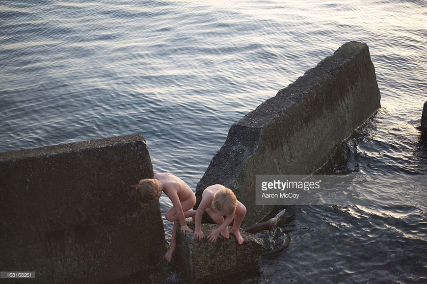 Boys play on a broken retaining wall (Мальчики, играющие на разрушенном волнорезе)