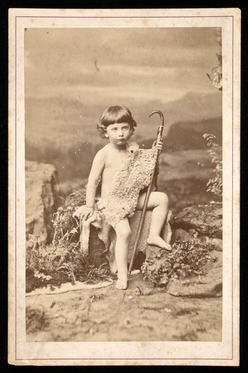 Mounted photograph of Edmund von Motesiczky as a young child seated on a boulder dressed in a sheepskin toga, holding a shepherd’s crook (Фотография Эдмунда фон Мотезички в детстве, сидящего на валуне, одетого в тогу из овчины, с пастушьим посохом в руках), c.1870